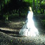 She wander/wonders film directed by Davina Kirkpatrick, music by Sam Hardaker, cameras Ryan Sharp, Mark Guthrie, . A woman in a glass dress walks the paths of the glory wood Dorking and Prussia Cove Cornwall. An embodiment of grief and loss