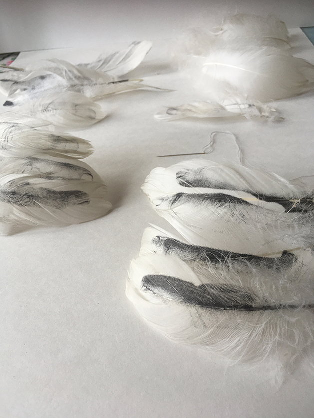 vessels made from swans feathers with hands screen printed onto them