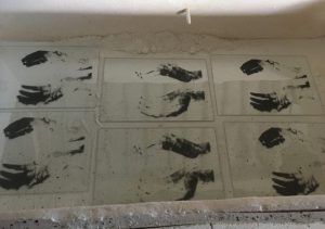 hand images screenprinted onto glass panels waiting to be fired in the kiln