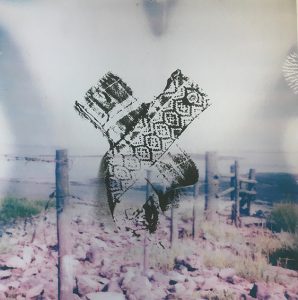 black screen printed tatters over enlarged polaroid image of fence at black rock