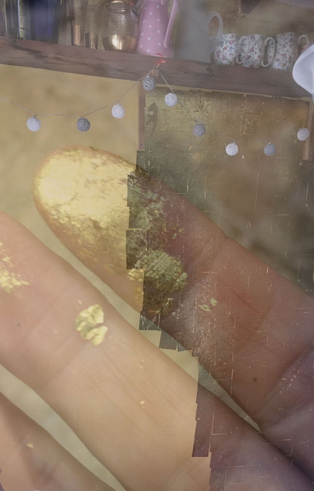 two photos superimposed over each other of a wall partially gold leafed and my fingers with gold leaf on the fingertips.