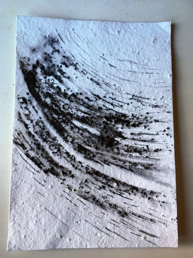 black ink swirled and windswept on seed paper