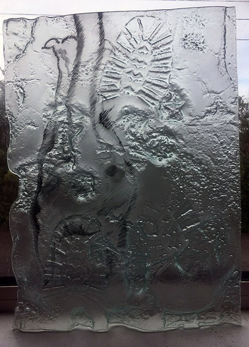 cast glass with footprints, paw prints and sketch image of Ulf walking in fired glass paint.