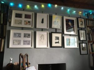A photograph of a wall of framed pictures and fairy lights in my living room.