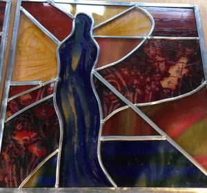 leaded stained glass with etched blue figure, red etched flowers and pink and blue handblown streaky glass to give an impression of sunrise/sunset.
